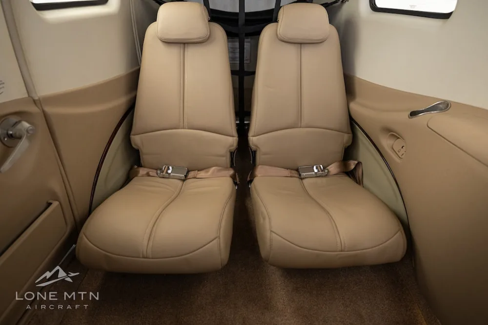 Two tan leather passenger seats in the rear cabin of an aircraft.