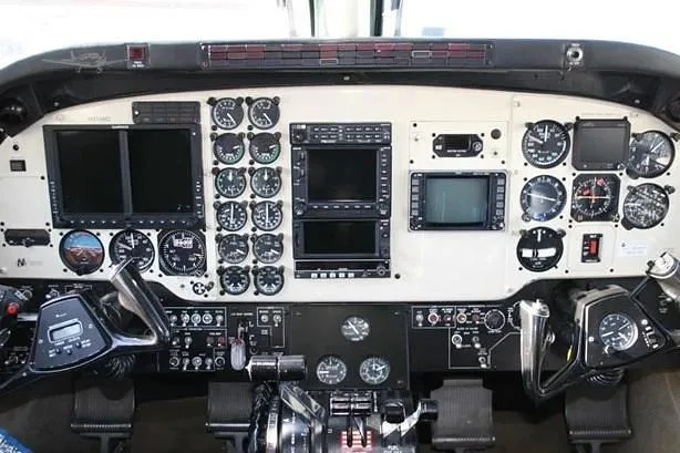 A detailed view of the aircraft cockpit instrument panel with multiple analog gauges and digital displays.