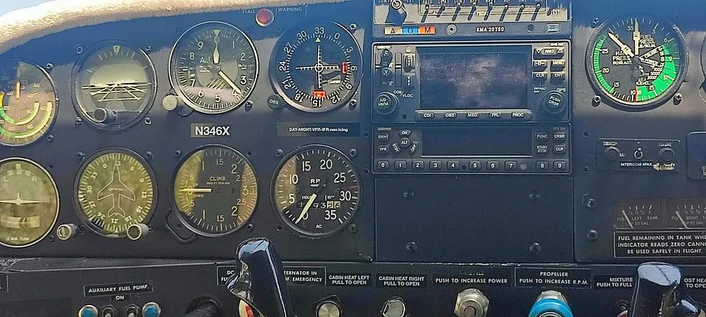 The cockpit instrument panel of N346X, featuring analog gauges and a Garmin GPS unit.