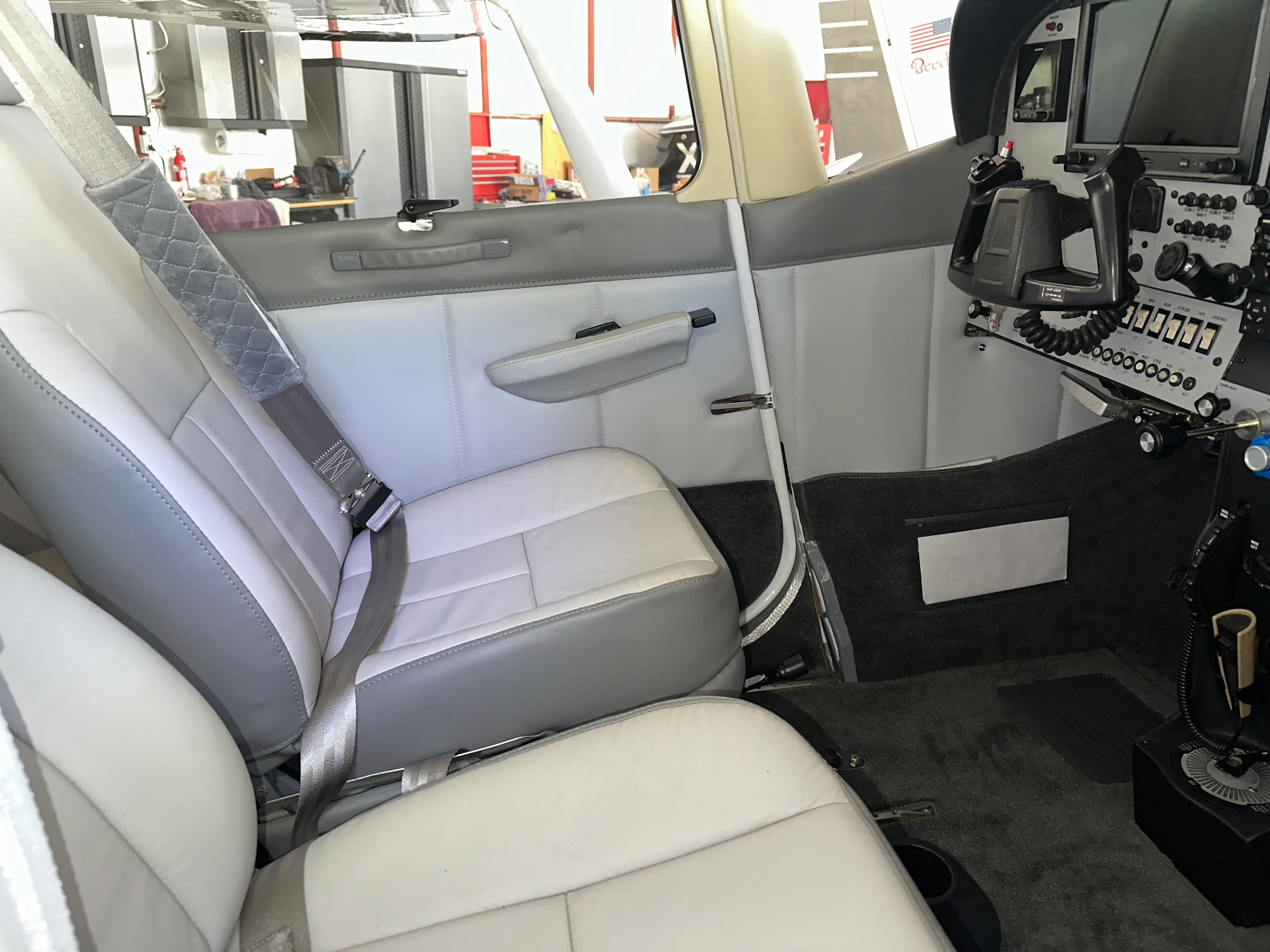 The light grey and white interior of the Cessna 182 cabin, showing the front passenger seat and part of the cockpit.