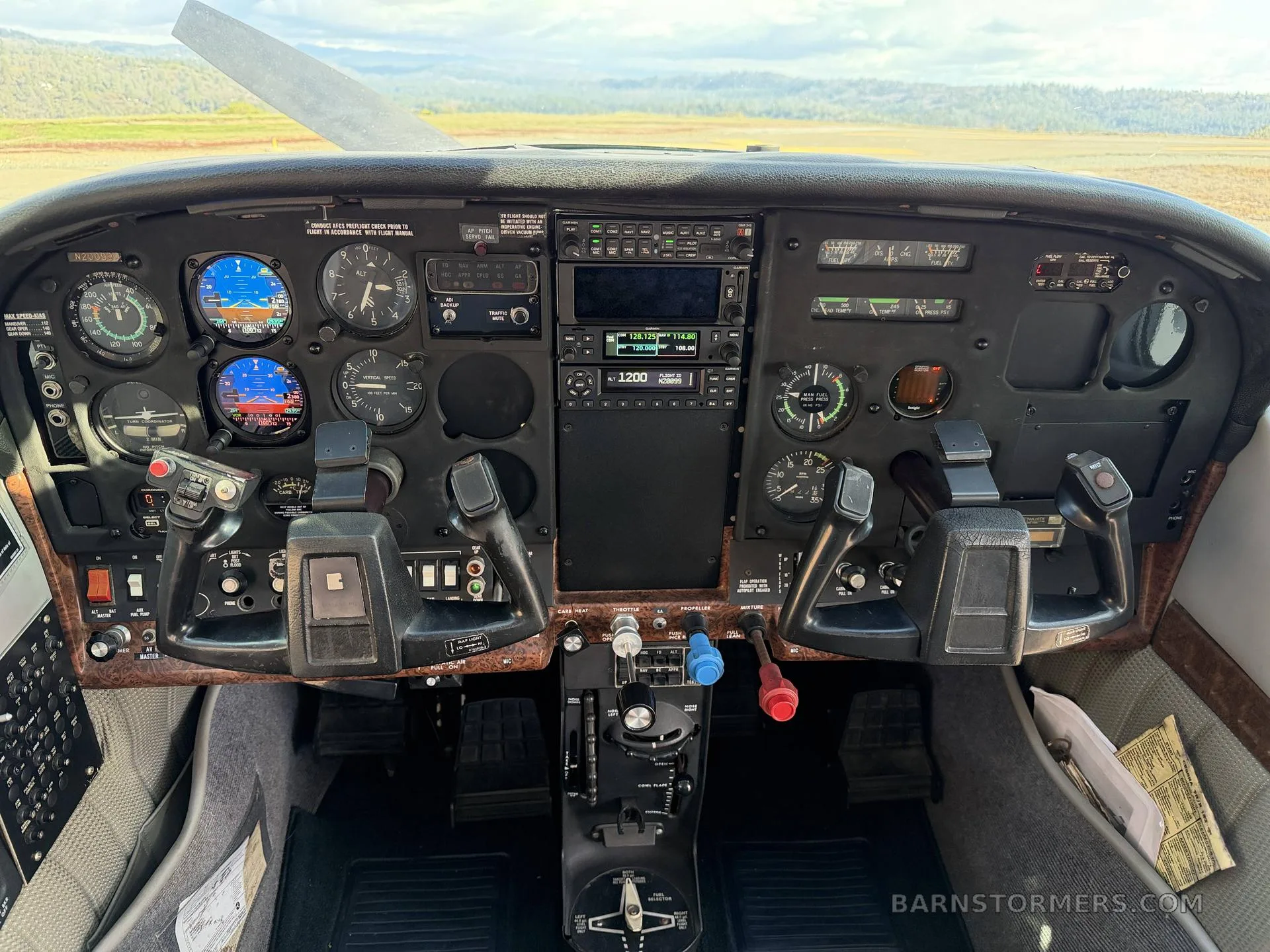 The cockpit of a Cessna aircraft, showing the instrument panel with analog gauges, digital displays, and yokes.
