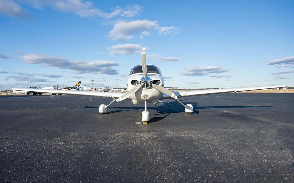 A head-on view of a white Cirrus SR20 aircraft, registration N639DR, with its propeller centered, parked on an asphalt tarmac.