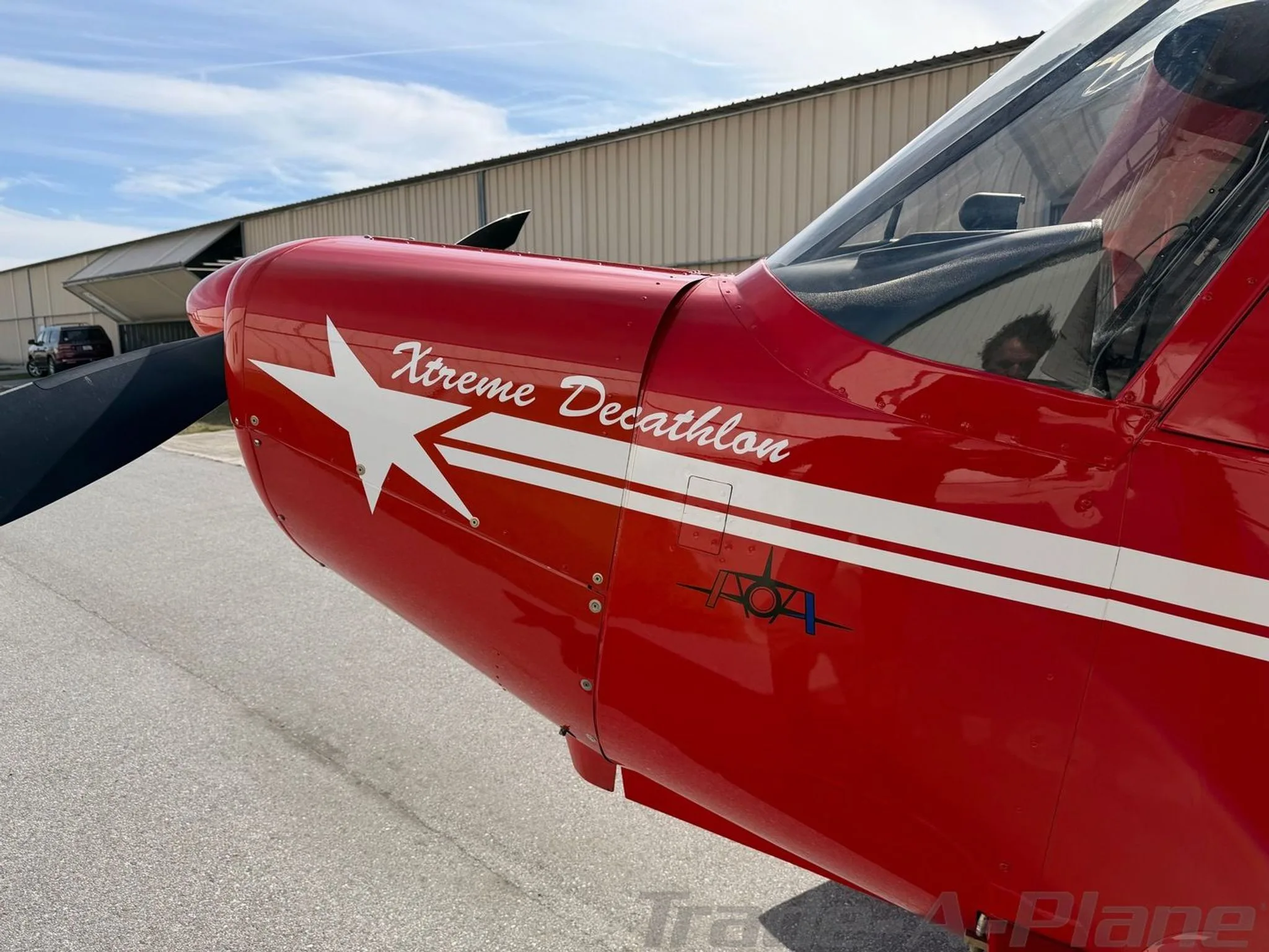 A close-up of the red American Champion Xtreme Decathlon's nose, showing 'Xtreme Decathlon' text and a white star logo.