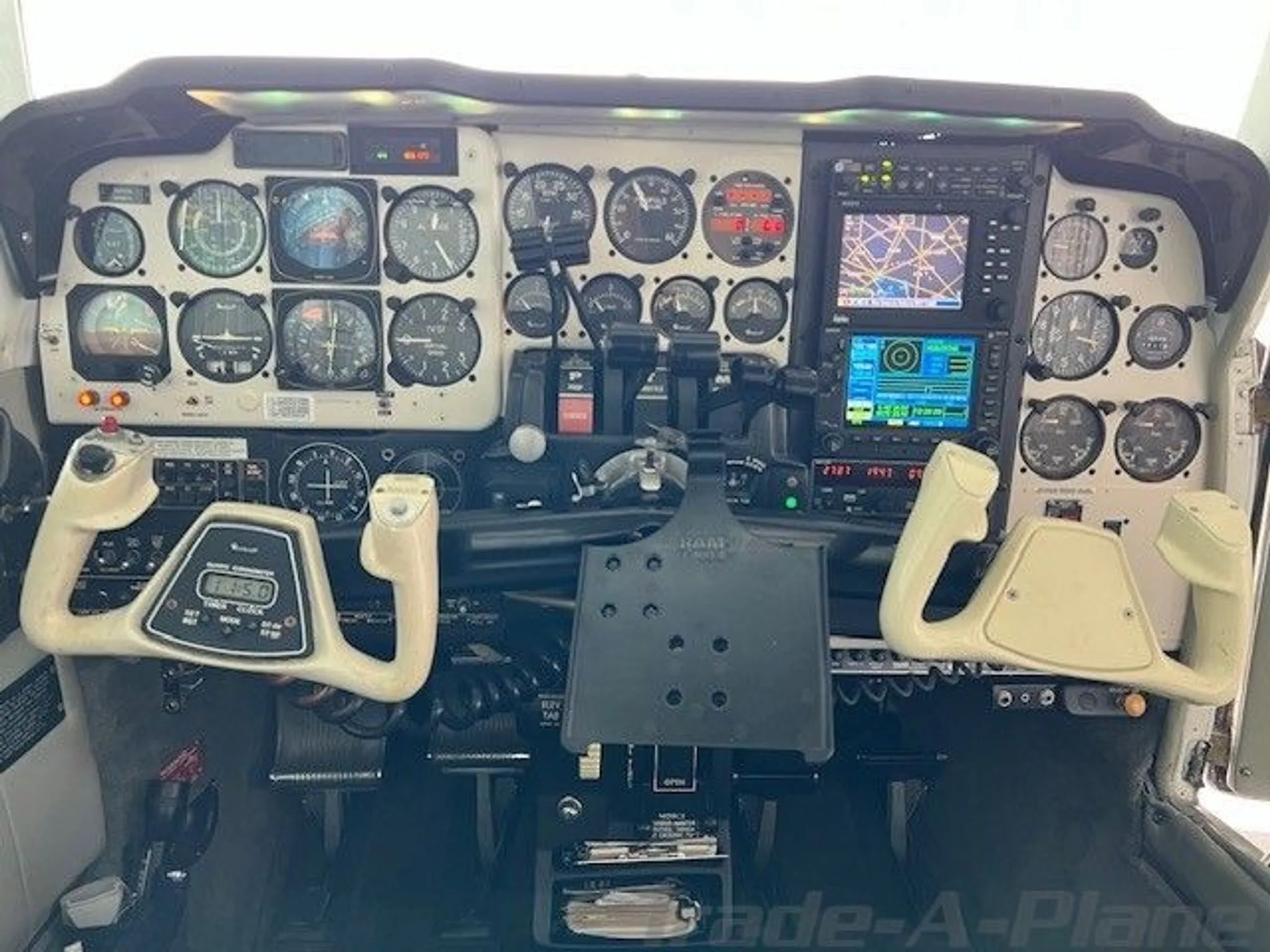 The cockpit of a twin-engine aircraft, showing the instrument panel with analog gauges and two control yokes.