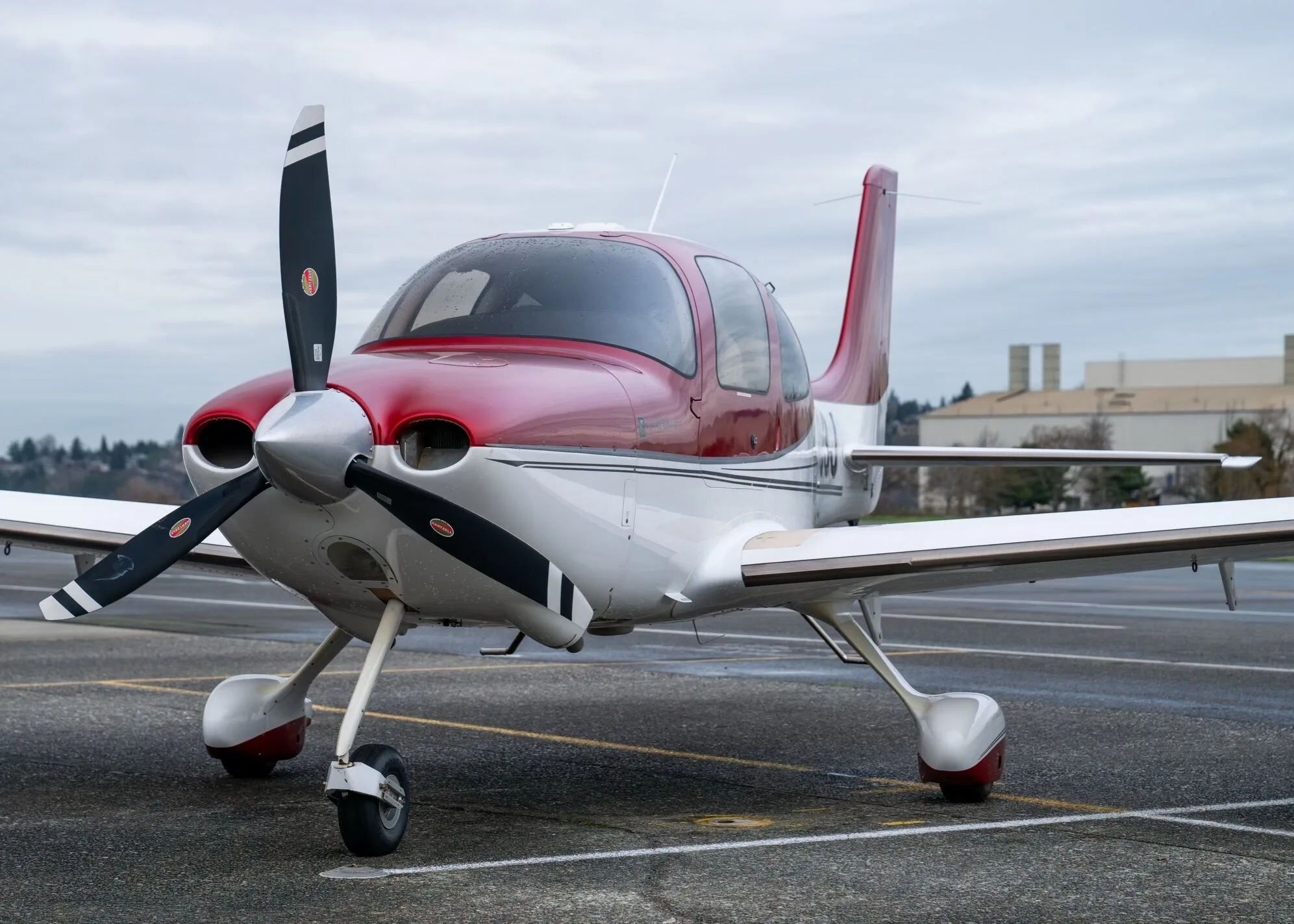 A close-up front view of the red and white Cirrus SR22 aircraft, N1783J, on a tarmac.