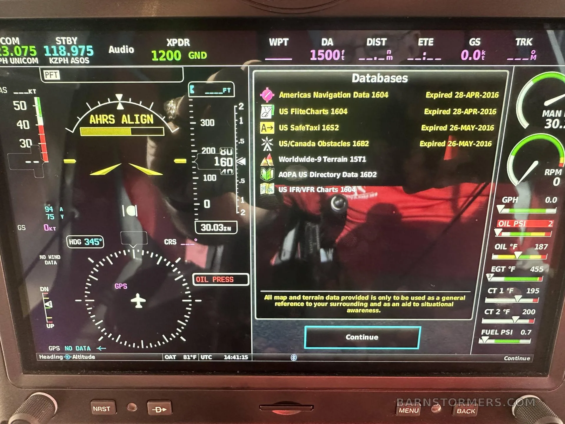 A close-up of an aircraft's Garmin display shows flight data, engine parameters, and expired navigation databases.