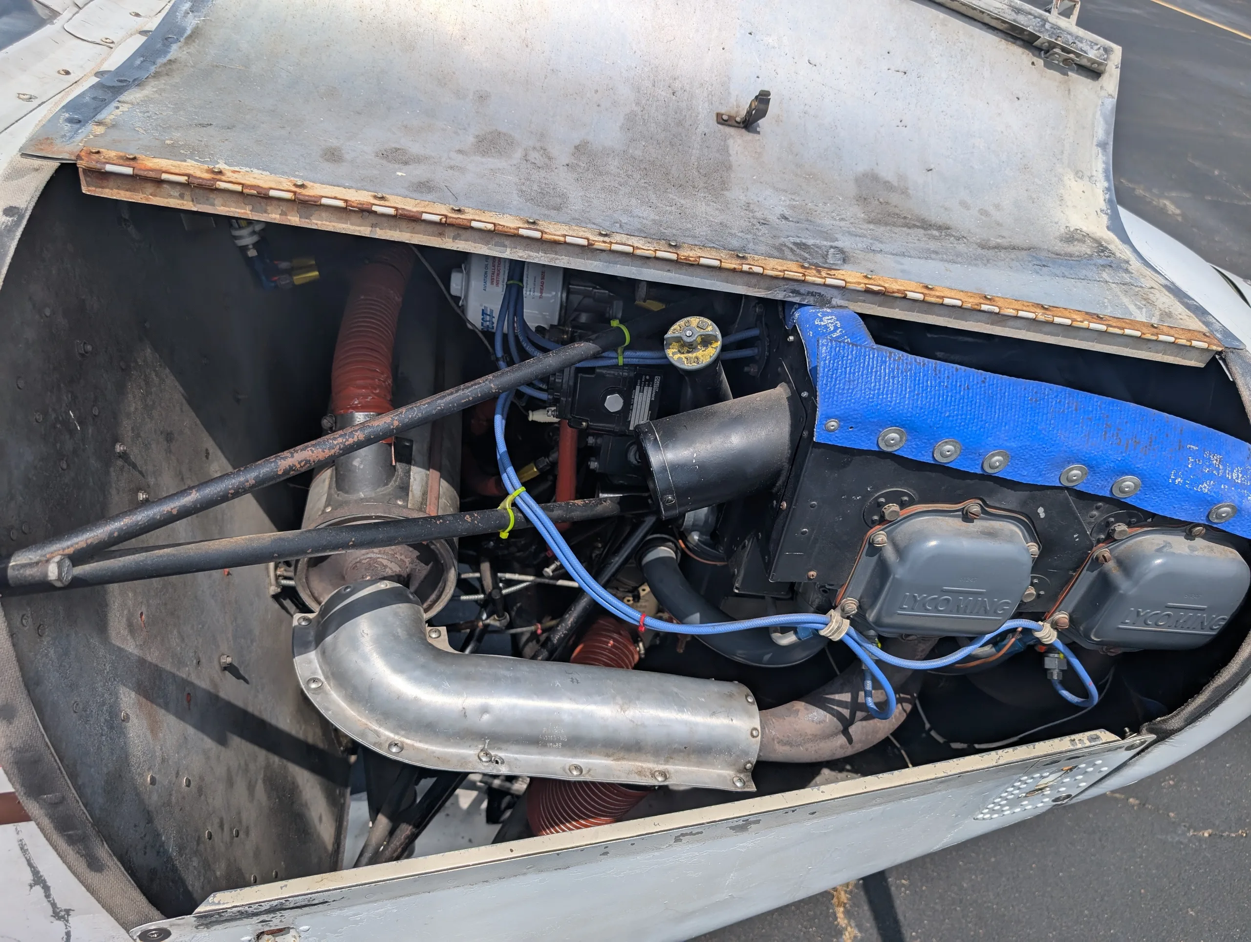 An open engine cowling reveals the Lycoming engine of the Piper Cherokee aircraft.