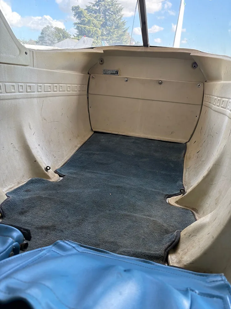 The beige rear cargo area of the aircraft with a blue carpeted floor.