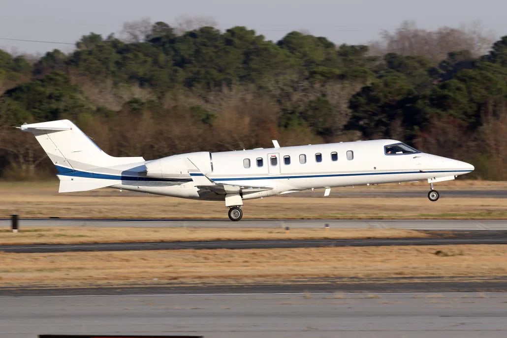 A Learjet aircraft is landing on a runway.