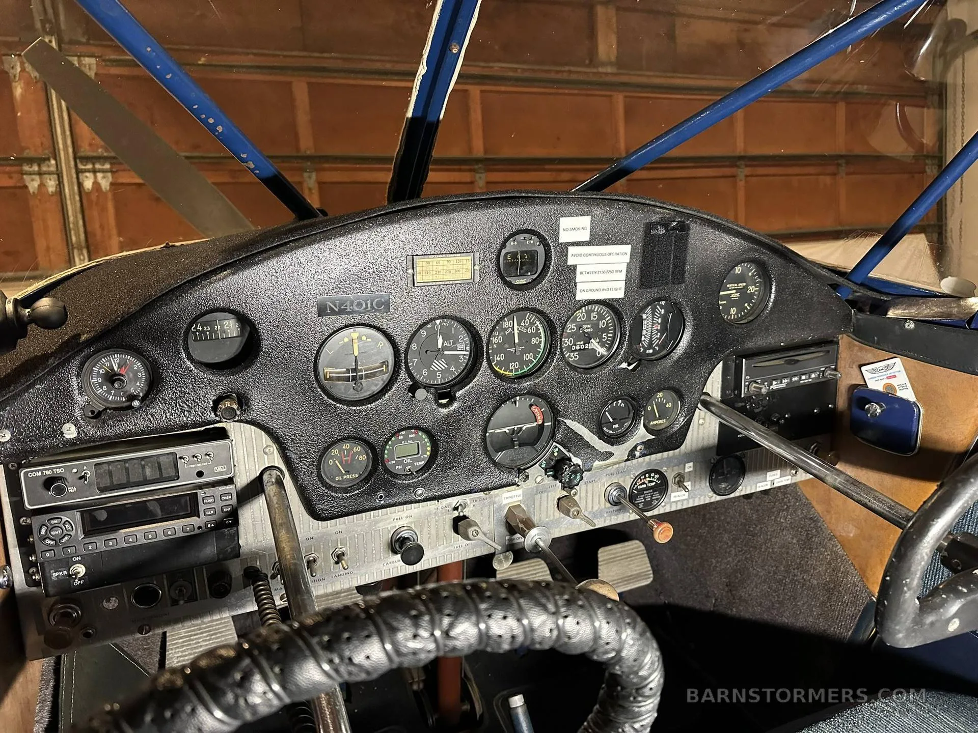 The instrument panel and controls of the Stinson aircraft, showing various gauges and avionics.