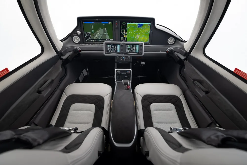 The modern cockpit of a Cirrus SR22T aircraft with a glass panel display and two-tone seats.