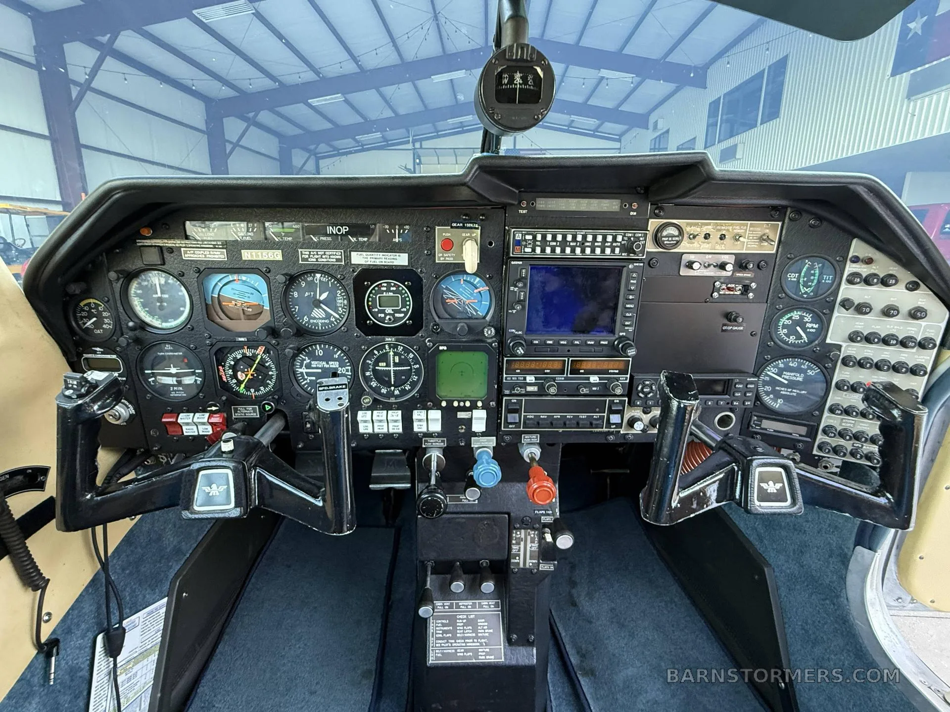 The cockpit of a small aircraft, featuring a complex instrument panel with analog gauges and a digital display.
