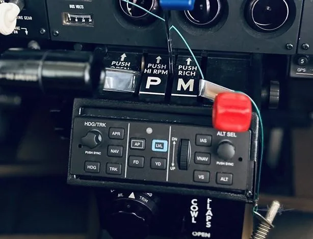 A close-up of the aircraft's center console with engine controls and an autopilot panel.