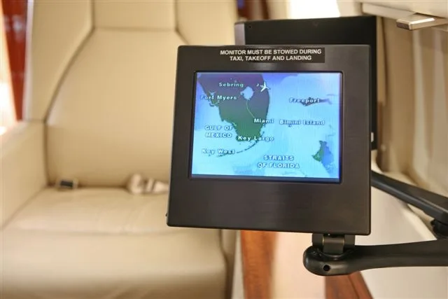 A monitor displays a map in the aircraft's interior.