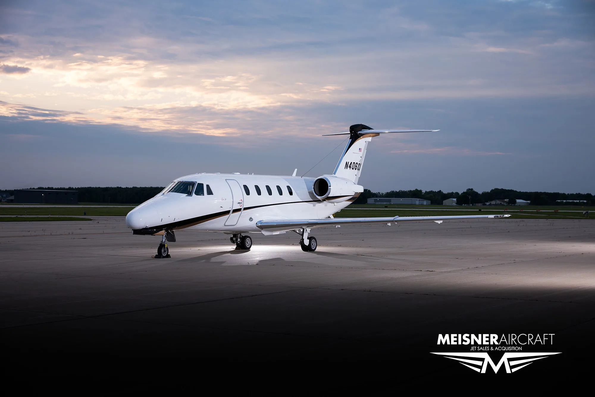 A white and black Cessna Citation business jet (N406CU) parked on a tarmac at dusk.
