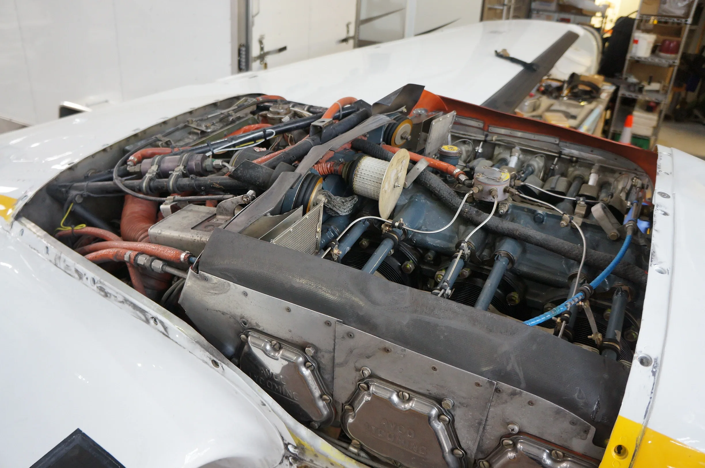 An open engine cowling reveals the detailed components of a Lycoming aircraft engine.