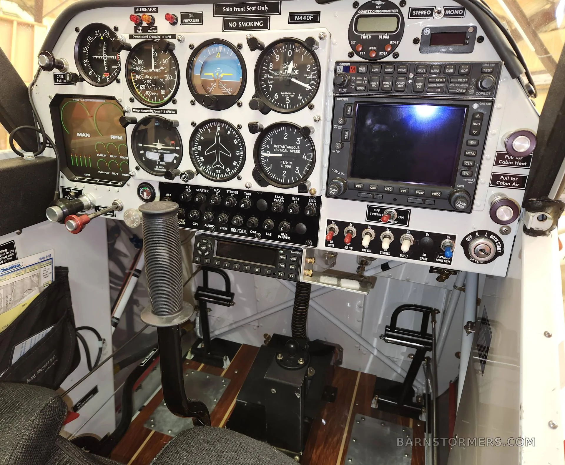 A detailed view of the aircraft's instrument panel with analog gauges, a modern digital display, and controls.