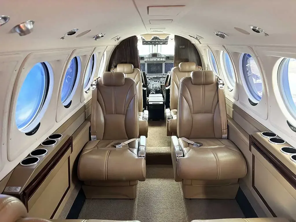 The aircraft's interior cabin with tan leather seats, looking forward towards the cockpit.