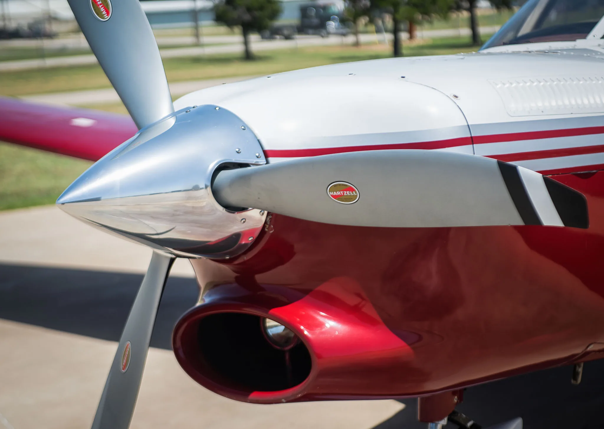 A detailed view of the polished propeller and red engine cowling of the aircraft.