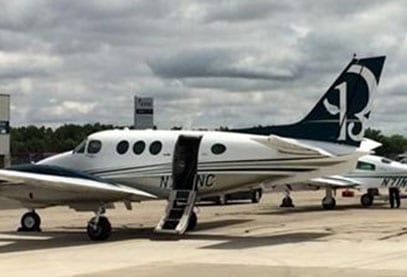A Beechcraft King Air with the door open and stairs extended.