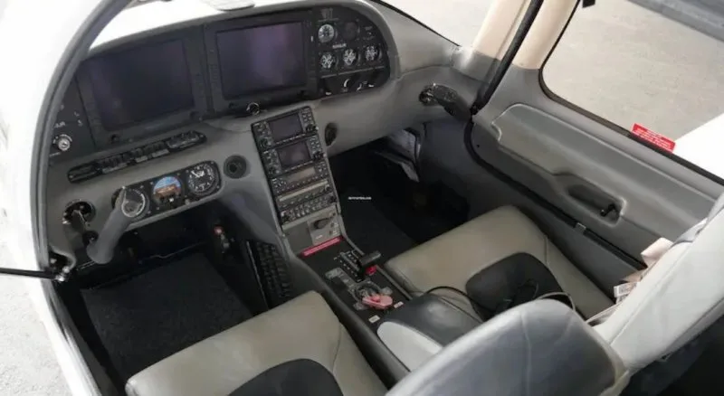The cockpit of a Cirrus SR22, featuring multiple screens, instruments, and controls.