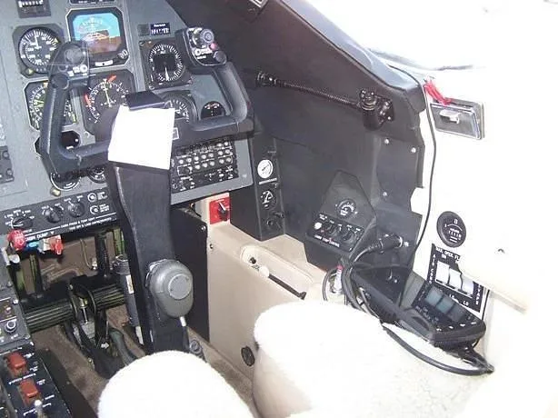 The pilot's side of the cockpit showing the control yoke, instrument panel, and side console.