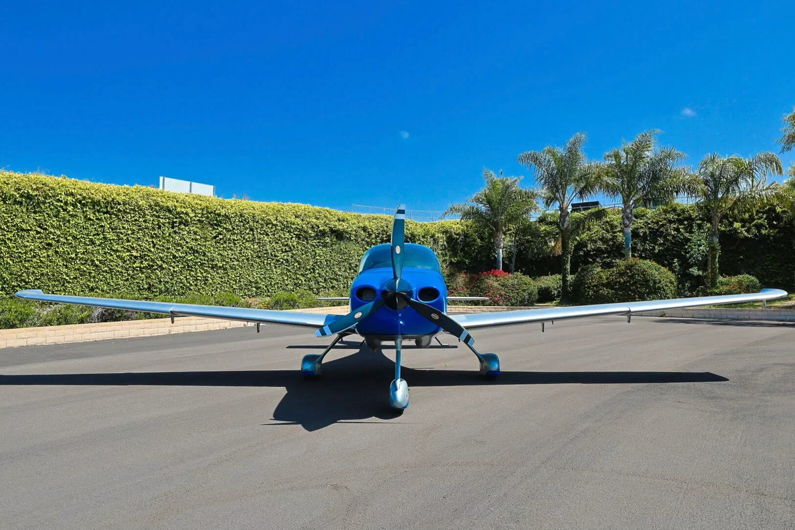 A head-on view of the blue and silver Cirrus SR20 aircraft N333YY parked on an asphalt ramp.