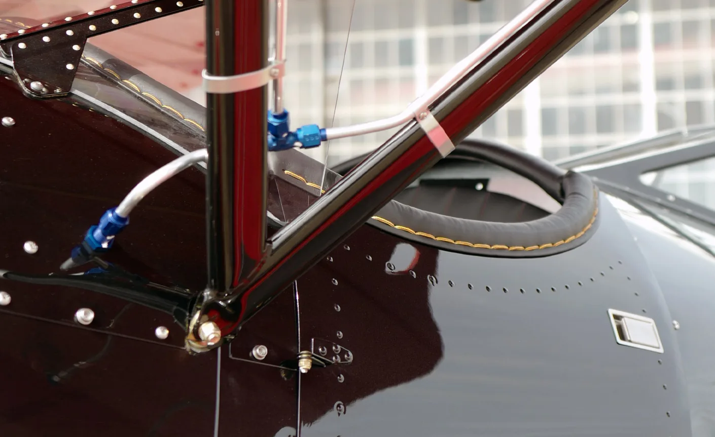 Close-up of the frame and rivets on a black and red biplane.