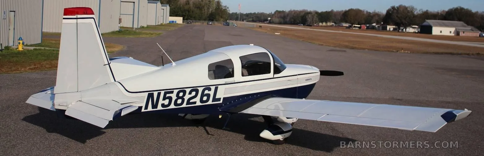 A white and blue Bobcat aircraft (N5826L) parked on an airfield, viewed from the rear right side.