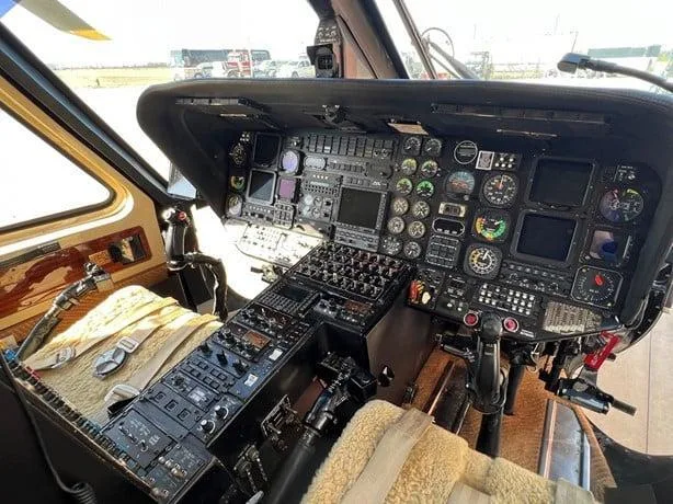 The helicopter's cockpit features numerous dials, screens, and control panels from the pilot's perspective.