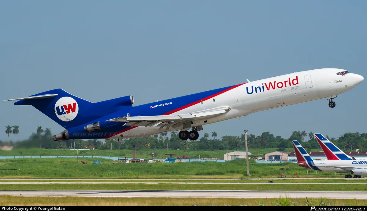 A UniWorld Air Cargo Boeing 727-200 in blue and white livery takes off from a runway, with another aircraft visible in the background.