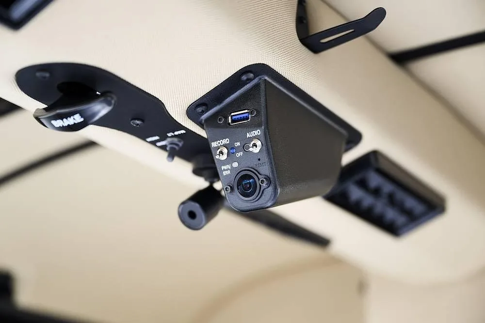 An overhead panel in an aircraft cabin showing a camera, USB port, and audio jacks.