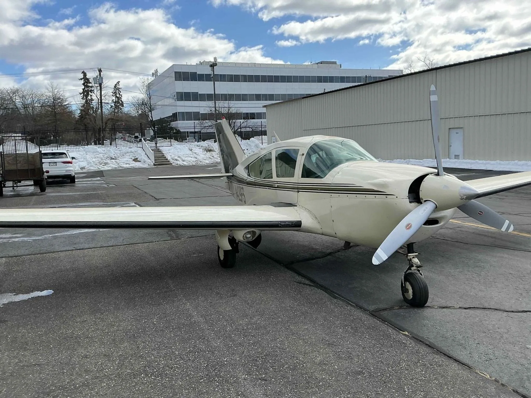 A front-quarter view of the white and green Bellanca Viking aircraft, N429FS, parked on an asphalt ramp.