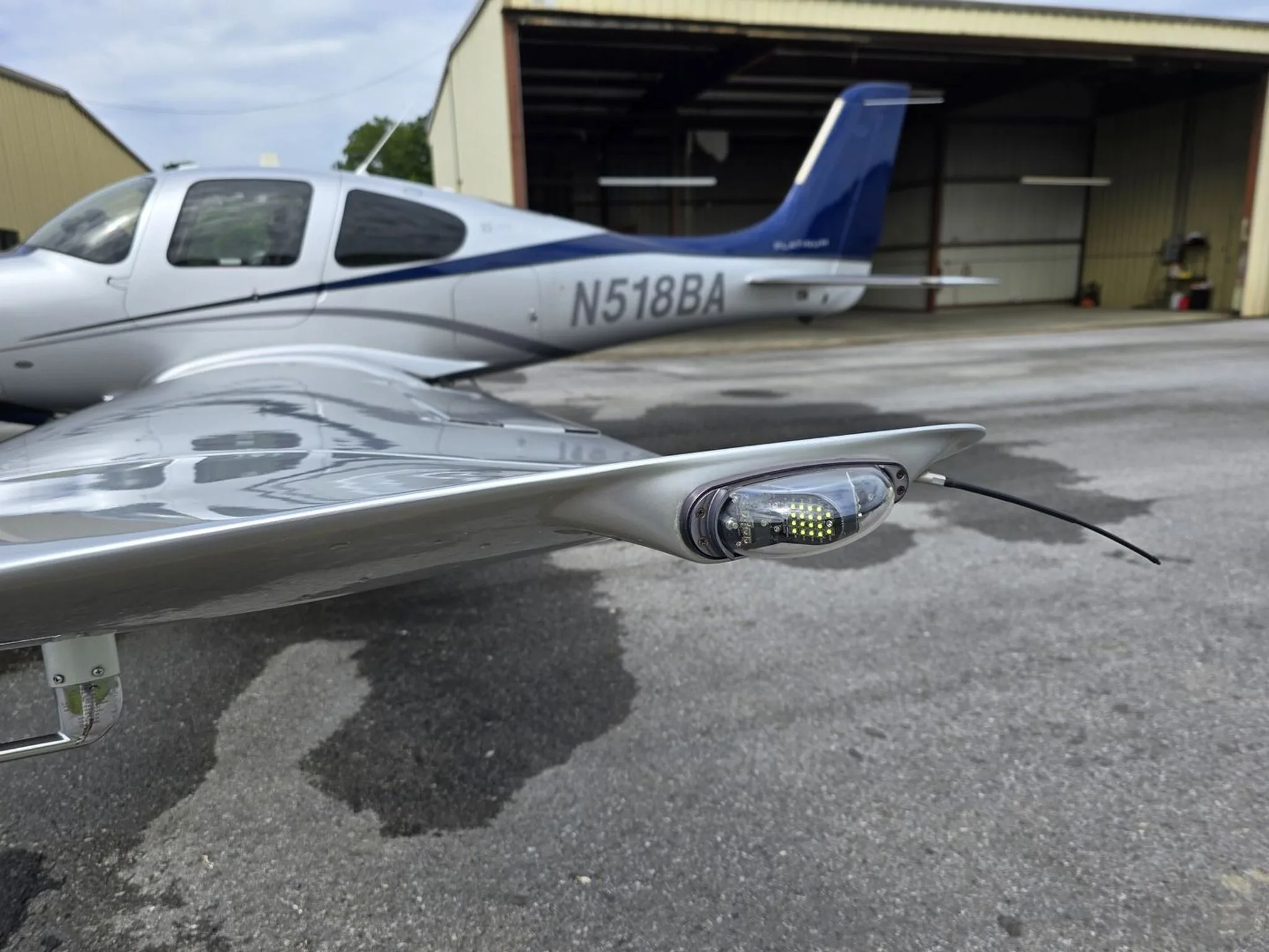 Close-up of the right wingtip and tail of a Cirrus SR22T aircraft, showing the navigation light and N518BA registration.