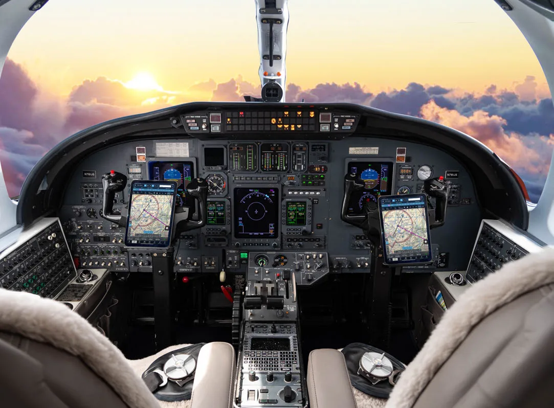 Aircraft cockpit with modern avionics and a view of the sky.