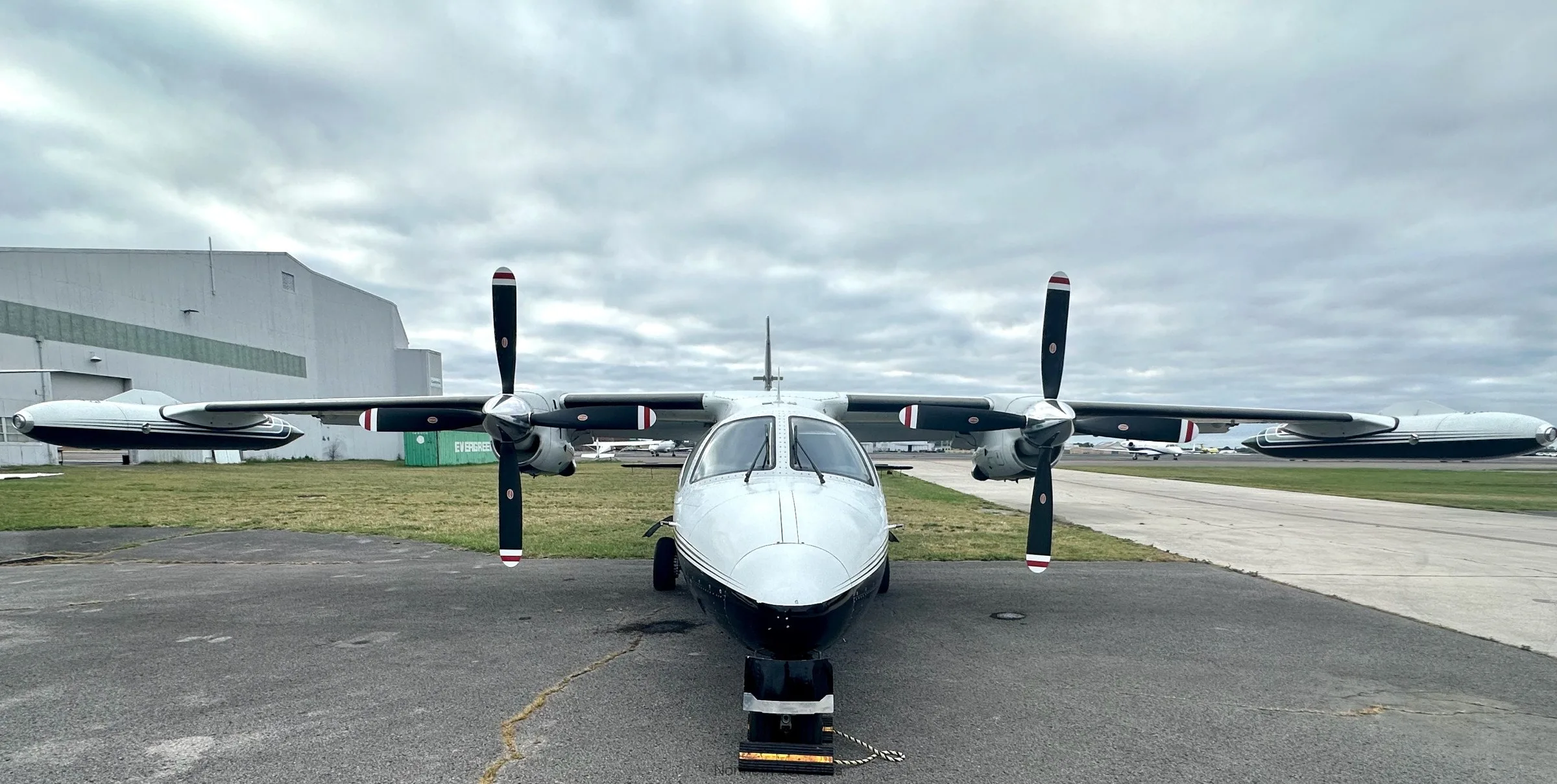 Front view of a white and black Shorts Skyvan aircraft on the tarmac.