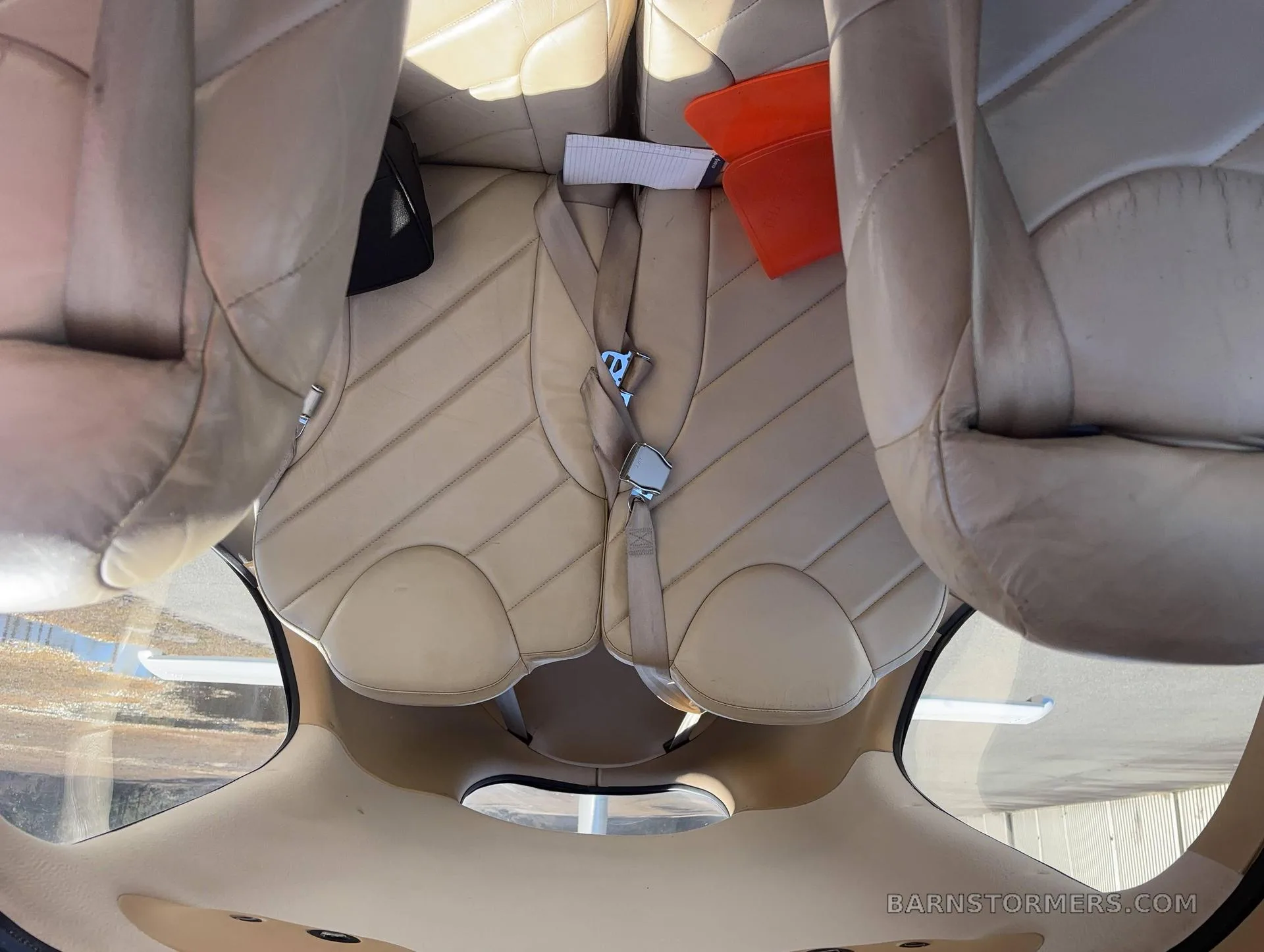 An overhead view of the tan leather seats in the aircraft's cabin.