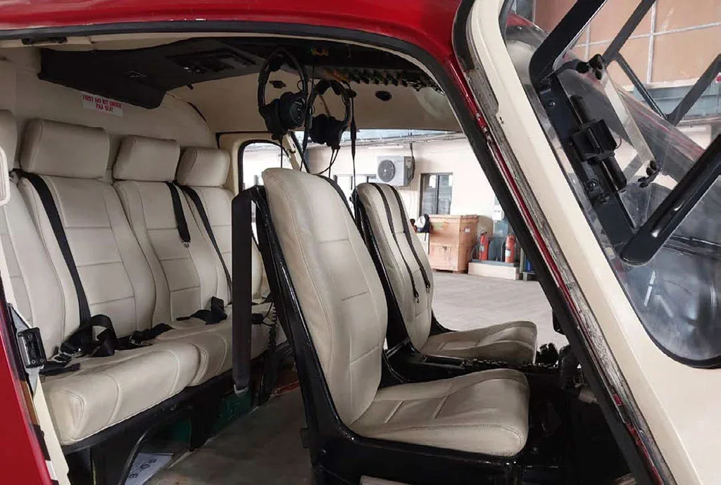 The light beige interior cabin seats and front pilot/co-pilot seats of the helicopter.