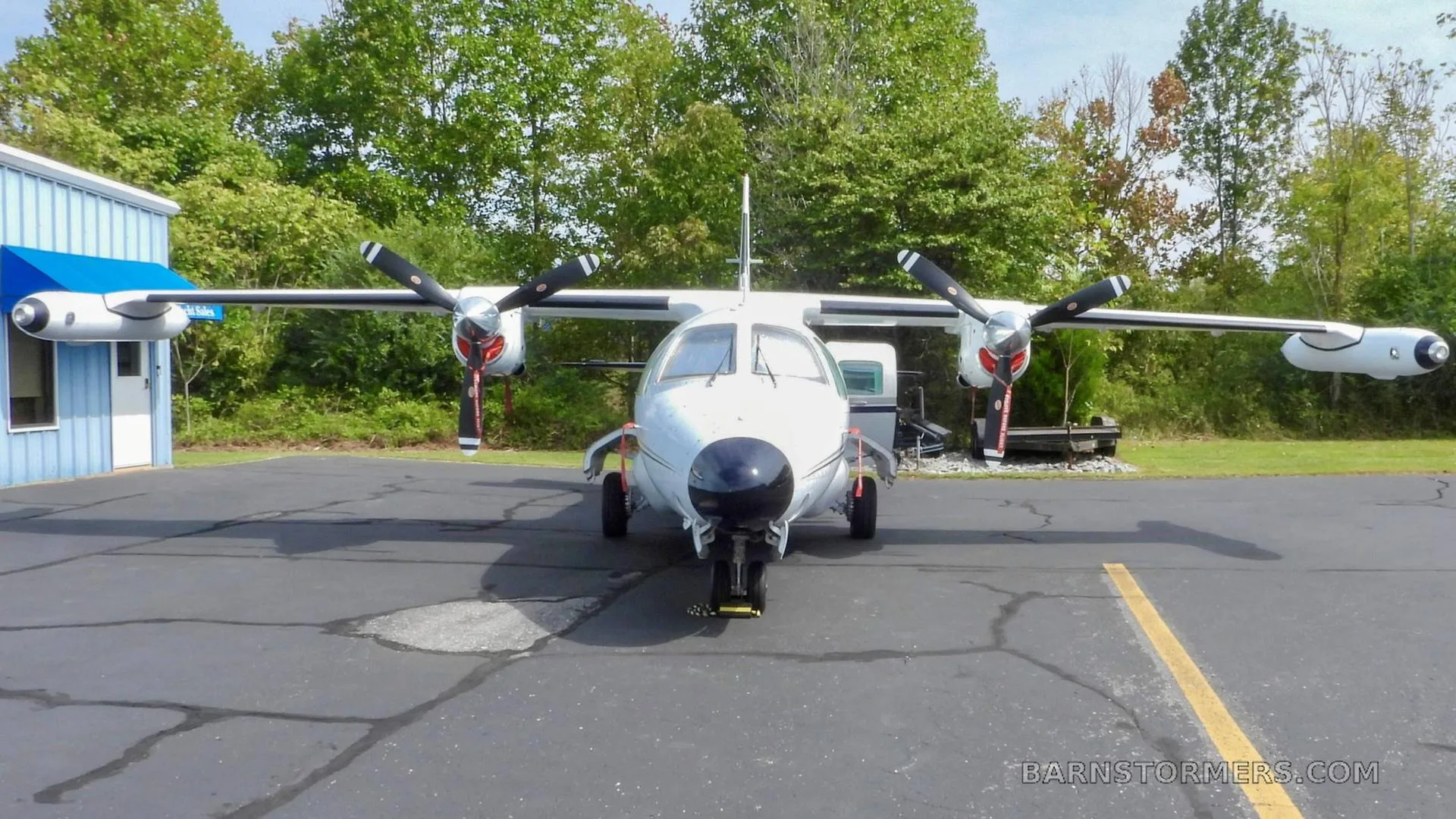 A white twin-engine turboprop aircraft, N621TA, viewed from the front, parked on an asphalt apron.