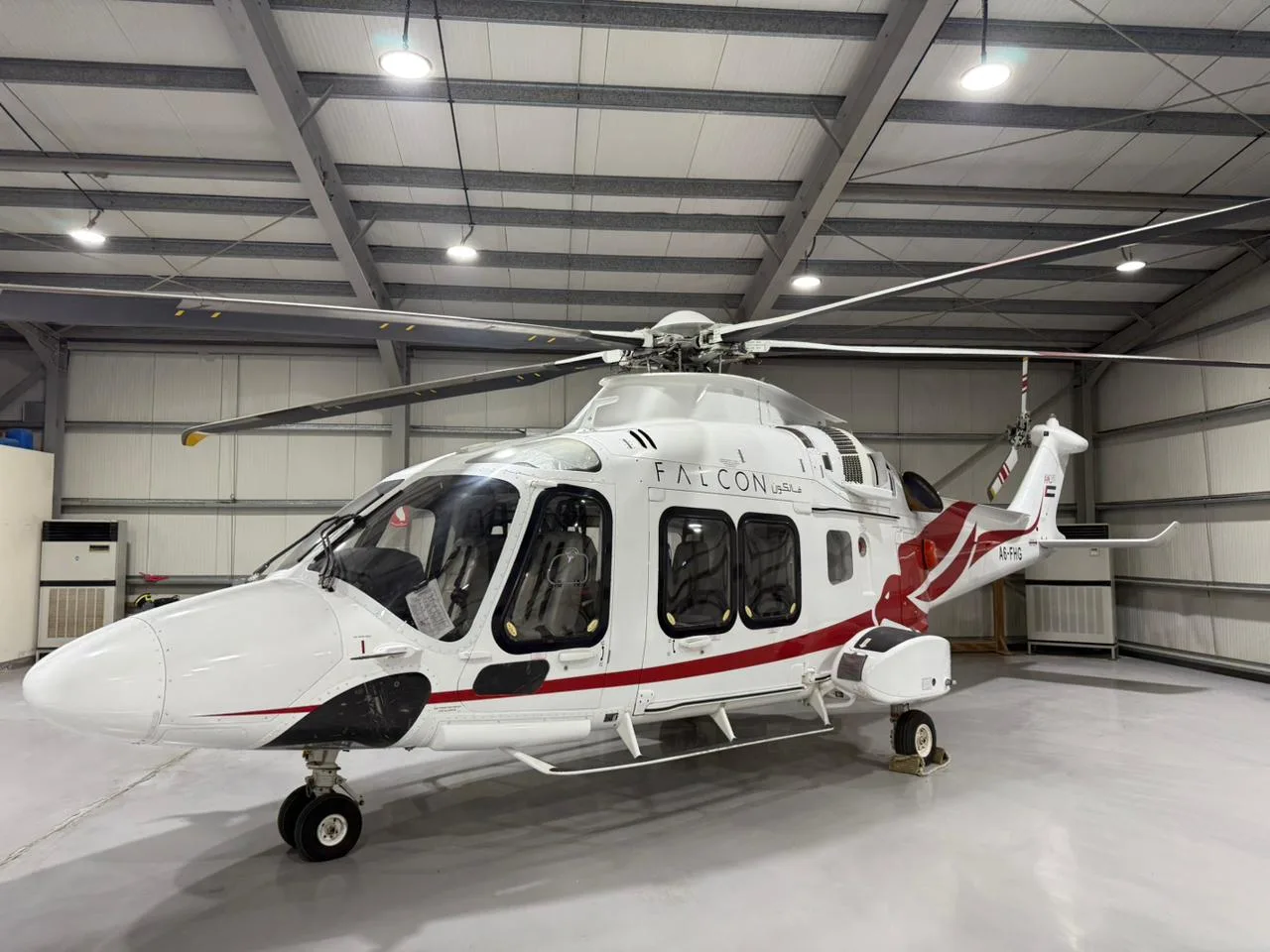 Front view of the A6-FHG helicopter parked inside a hangar.