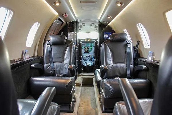 Forward cabin view with leather seats and cockpit in the background.