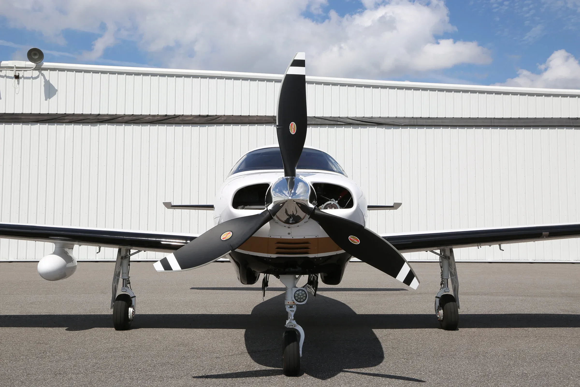 Close-up front view of a Piper Mirage aircraft showing the propeller and landing gear.