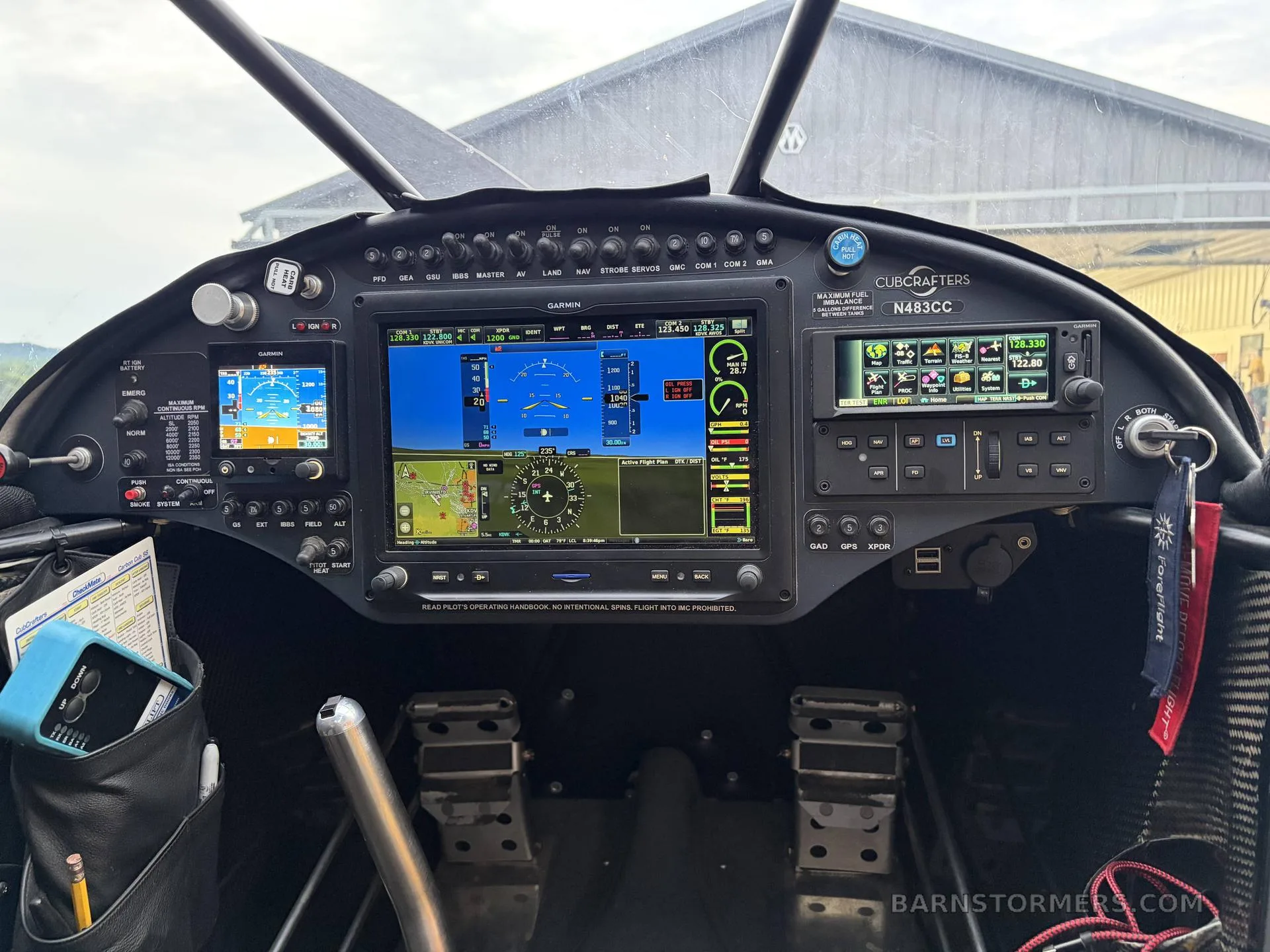 The cockpit of a CubCrafters aircraft showing multiple Garmin glass panel displays and flight controls.