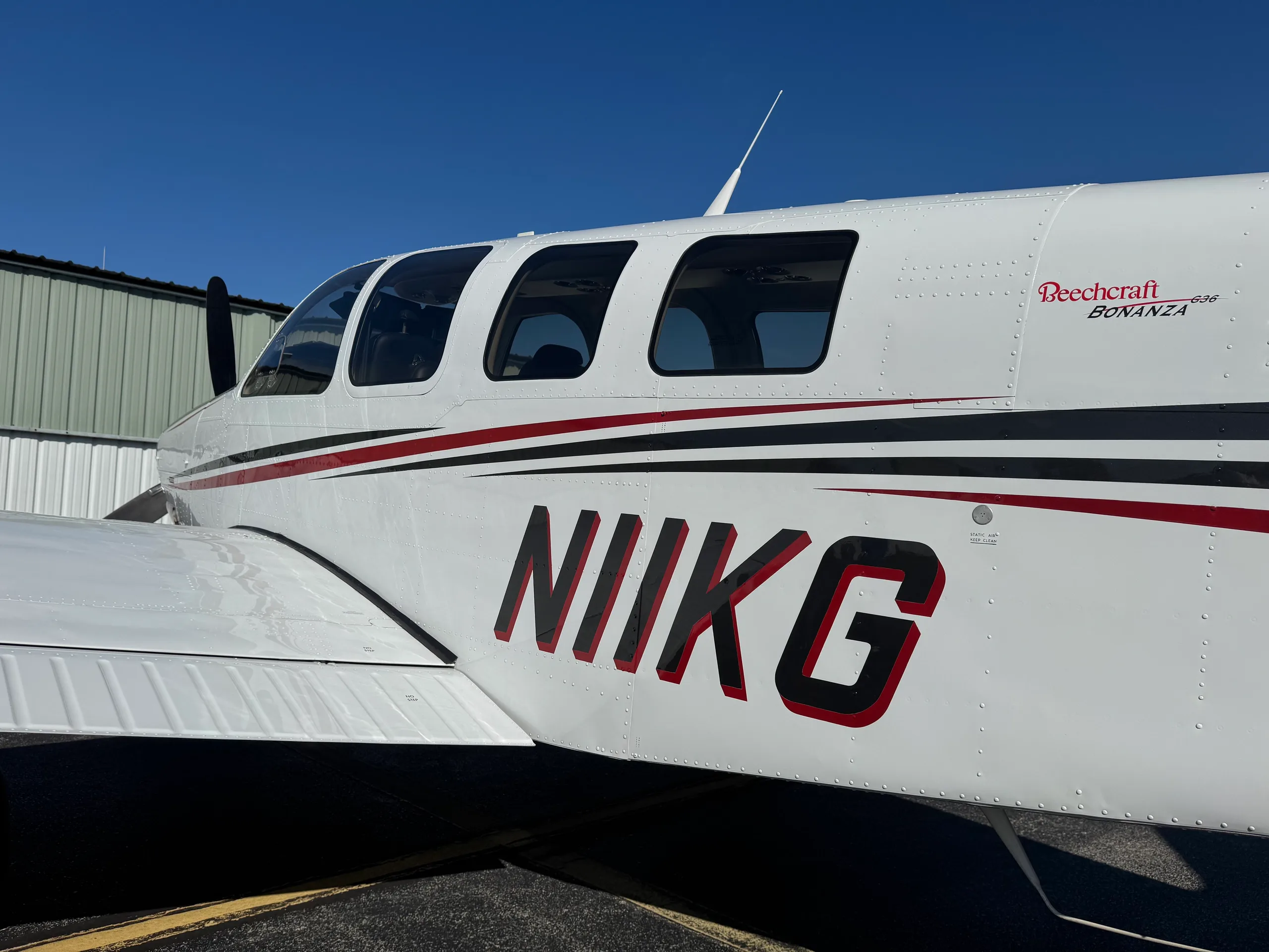 A detailed view of the Beechcraft Bonanza N11KG fuselage, highlighting the registration and paint scheme.