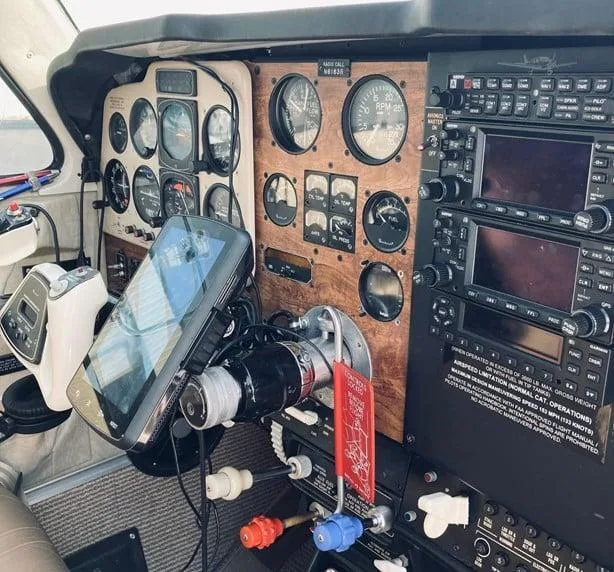 Detailed view of the aircraft's instrument panel showing analog gauges, avionics stack, and a mounted tablet.