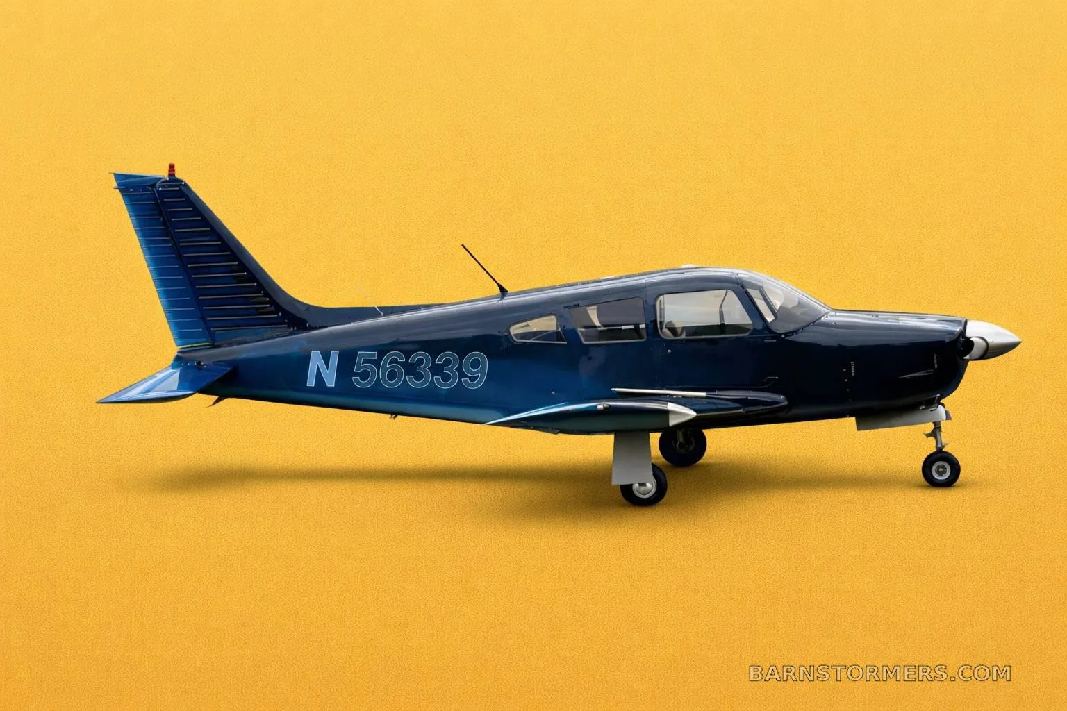 A dark blue single-engine propeller aircraft with registration N 56339 is shown in a side profile against a yellow background.