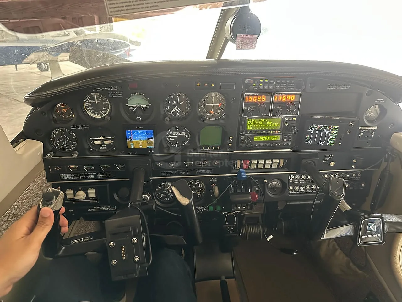 A pilot's view of a detailed aircraft instrument panel with multiple analog gauges and digital displays.