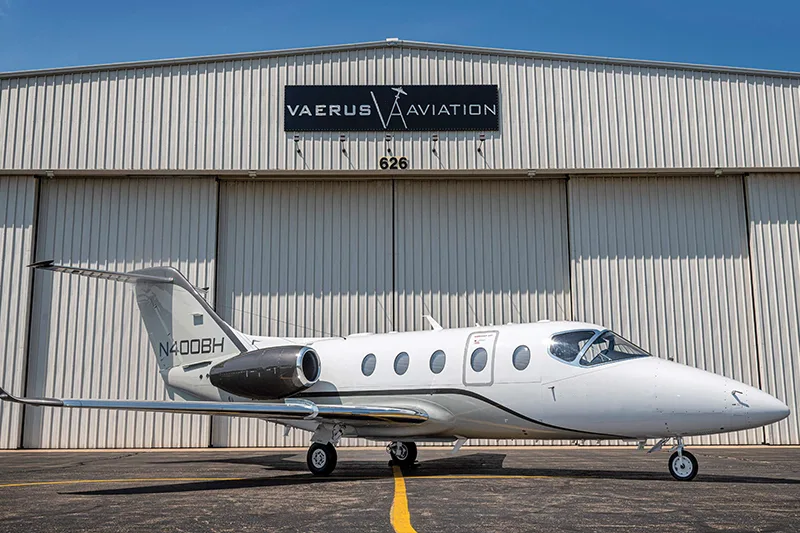 Side view of a Nextant 400XTi aircraft with registration N400BH parked in front of a hangar.