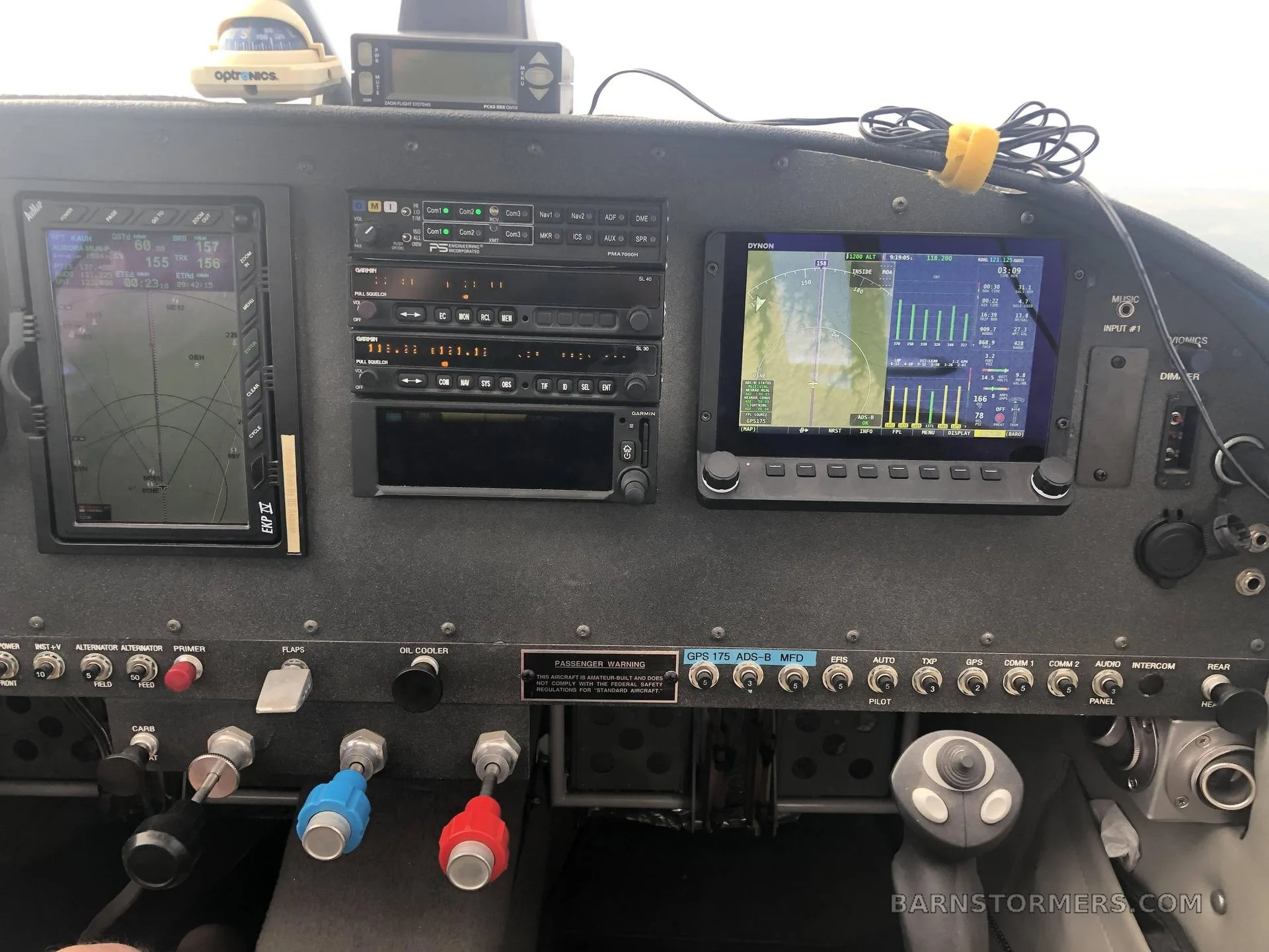The cockpit instrument panel features multiple digital displays, radios, and control levers.