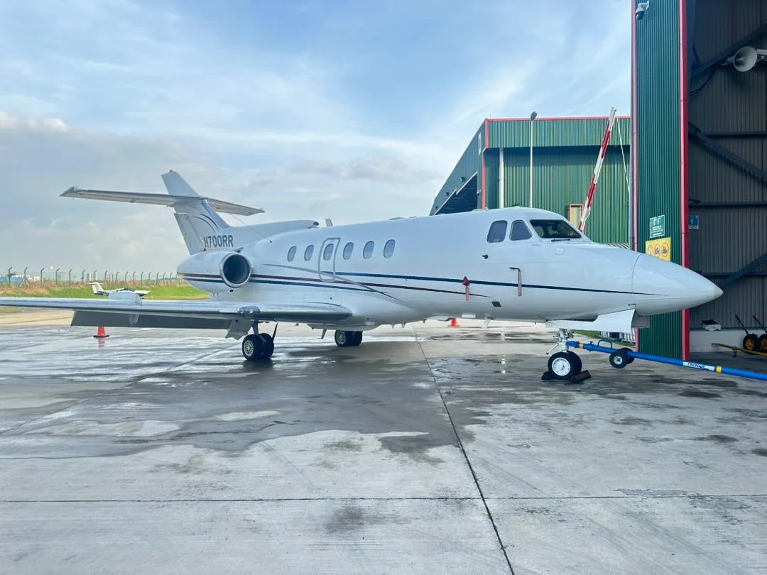 A Hawker 400XP aircraft with registration N700RR is parked outside a hangar.